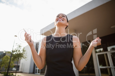 Happy businesswoman holding mobile phone