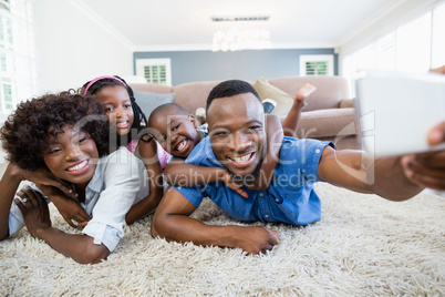 Happy family taking a selfie from mobile phone in living room