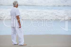 Senior man standing on the beach