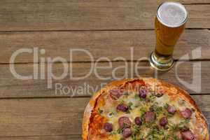 Delicious pizza served with a glass of beer