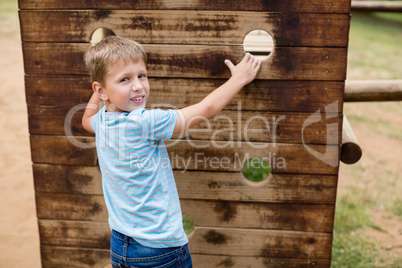 Boy climbing on a playground ride in park