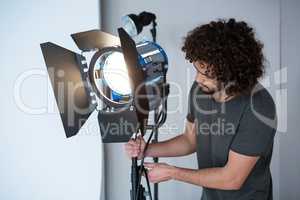 Photographer adjusting spotlight