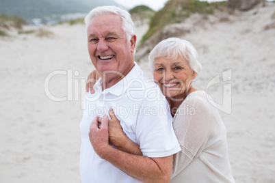 Senior couple embracing each other on the beach