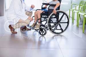 Doctor interacting with disable boy in corridor