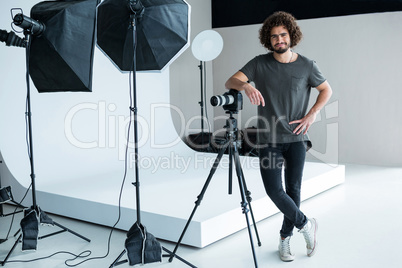 Happy male photographer standing in studio