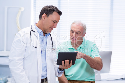 Doctor and senior patient using digital tablet