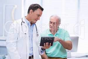 Doctor and senior patient using digital tablet