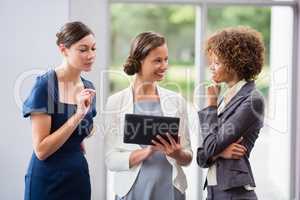 Business executives discussing over digital tablet