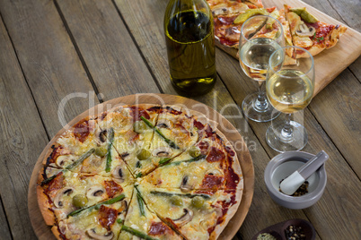 Italian pizza served with wine glasses and ingredients