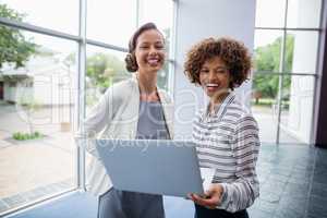 Cheerful business executives holding laptop