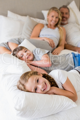 Parents and kids relaxing on bed in bedroom