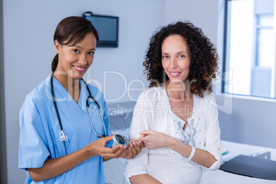 Portrait of doctor examining pregnant womans blood sugar