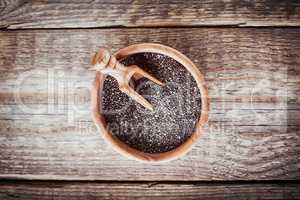 Chia Seeds with a spoon on a wooden table.