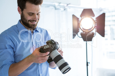 Male photographer reviewing captured photos in her digital camera