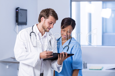 Doctors having discussion on clipboard