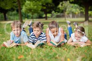 Kids lying on grass and reading books