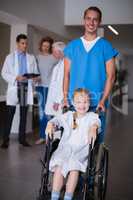 Doctor pushing disable girl in hospital corridor