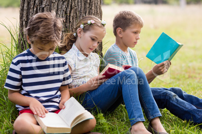 Kids reading books in park