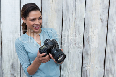 Happy female photographer standing in studio