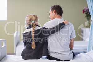 Rear view of daughter comforting her sick father