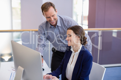 Businesswoman working at desk with colleague