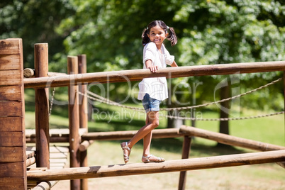 Girl playing on a playground ride in park