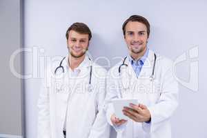 Portrait of doctors using digital tablet in corridor