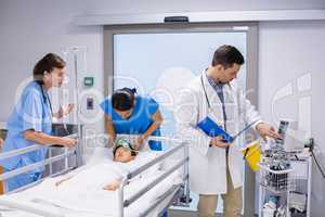 Doctors examining patient in ward