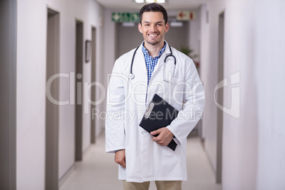 Portrait of smiling doctor standing with clipboard