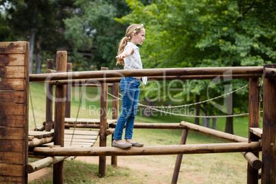 Girl playing on a playground ride in park