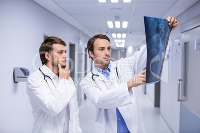 Doctors examining x-ray in corridor