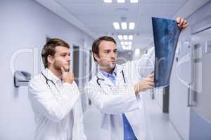 Doctors examining x-ray in corridor