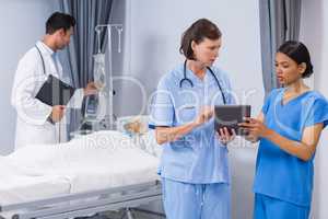 Doctor and nurse discussing over digital tablet