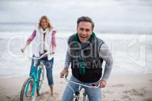 Mature couple riding bicycles on the beach