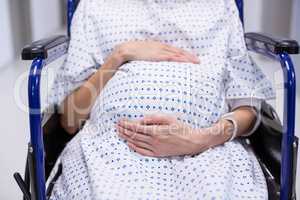 Mid section of pregnant woman sitting on wheelchair