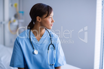 Thoughtful female doctor sitting in ward