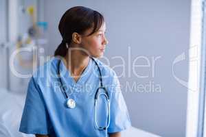 Thoughtful female doctor sitting in ward