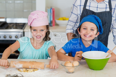 Mother and kids preparing food in kitchen