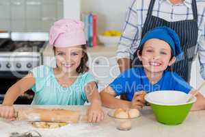 Mother and kids preparing food in kitchen