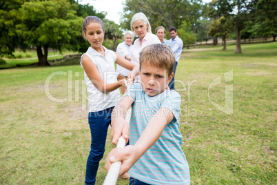 Multi-generation family pulling a rope in tug of war