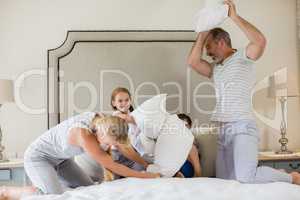 Cute family having a pillow fight in bedroom