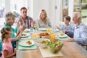 Multi- generation family having meal on dinning table