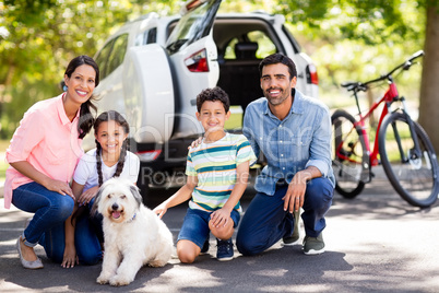 Happy family enjoying together with their pet dog in park