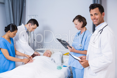 Doctors examining patient in ward