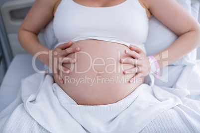 Mid section pregnant woman relaxing on hospital bed