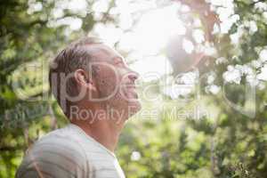 Man standing against bright sunlight at park