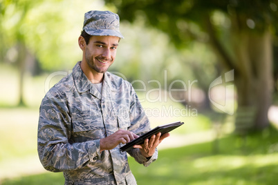 Soldier using digital tablet in park