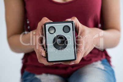 Mid section of female photographer holding old fashioned camera