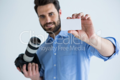 Male photographer showing visiting card in studio