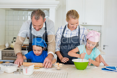 Parents and kids preparing food in kitchen